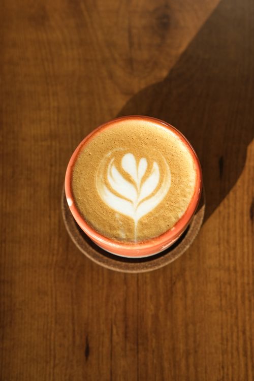 Free Top view of a cappuccino with elegant latte art on a sunny wooden table in Istanbul. Stock Photo