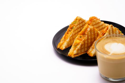 A plate of grilled cheese sandwiches with a latte. Perfect for breakfast.