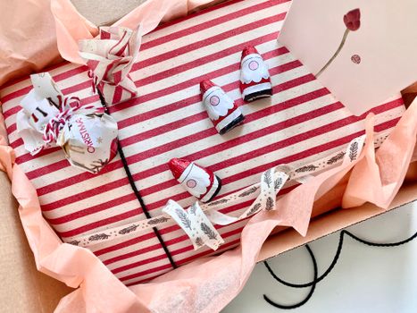A beautifully wrapped Christmas gift box with a striped design and festive decorations in an open package.