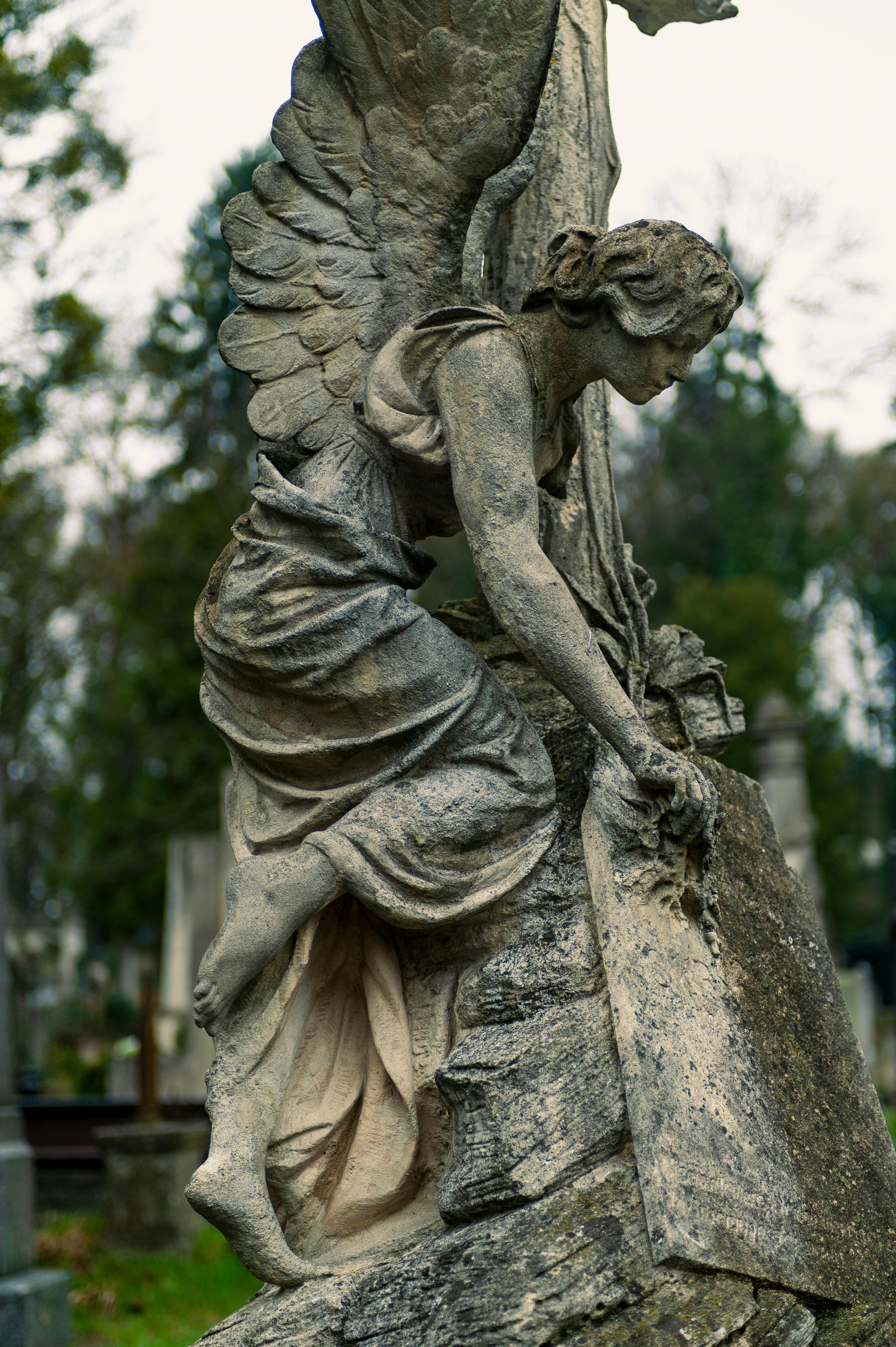 A detailed stone angel statue in a serene cemetery setting, evoking peace and reflection.
