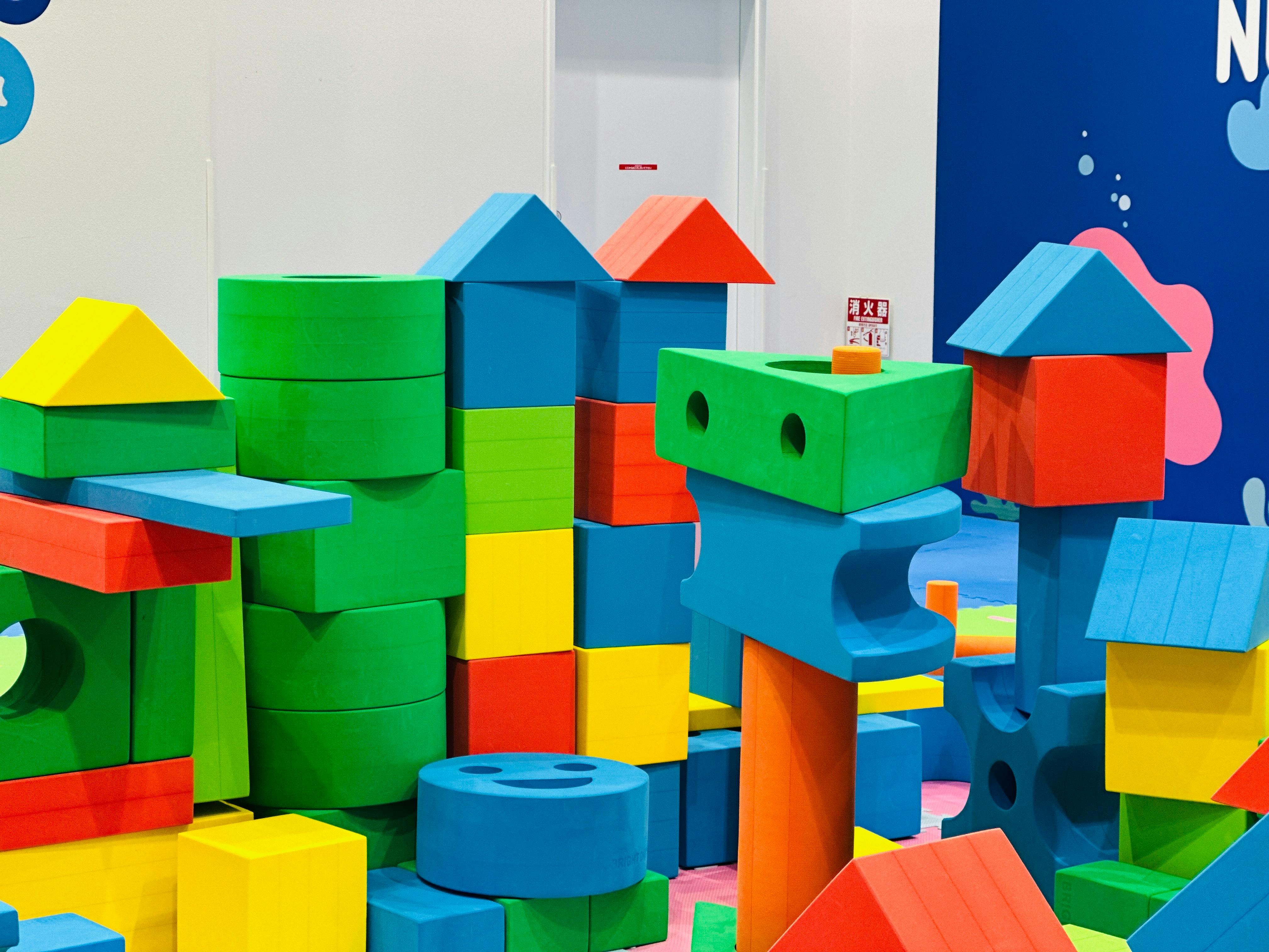 Vibrant foam building blocks stacked in an indoor children's play area.