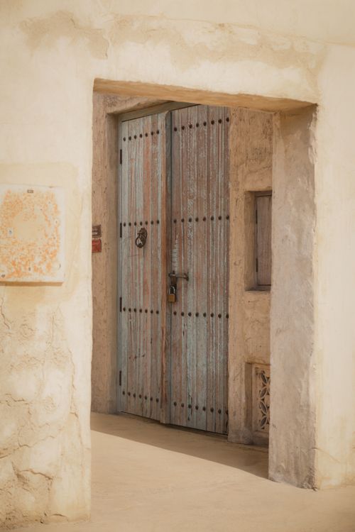 Free Rustic wooden door with metal studs in an aged stone wall, showcasing historical architecture. Stock Photo