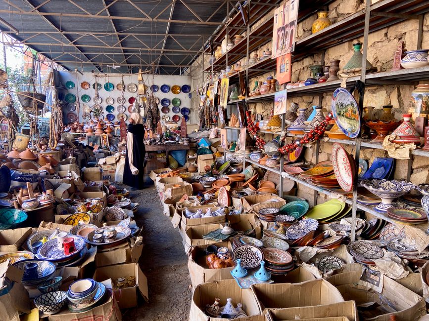 Traditional Moroccan pottery and ceramics displayed in bustling market stall, offering a vibrant cultural experience.