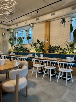 Stylish restaurant interior featuring greenery and modern furniture.