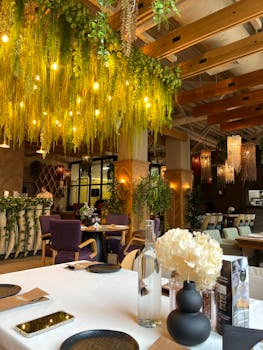 A chic restaurant interior featuring vibrant greenery and warm lighting, ideal for upscale dining.