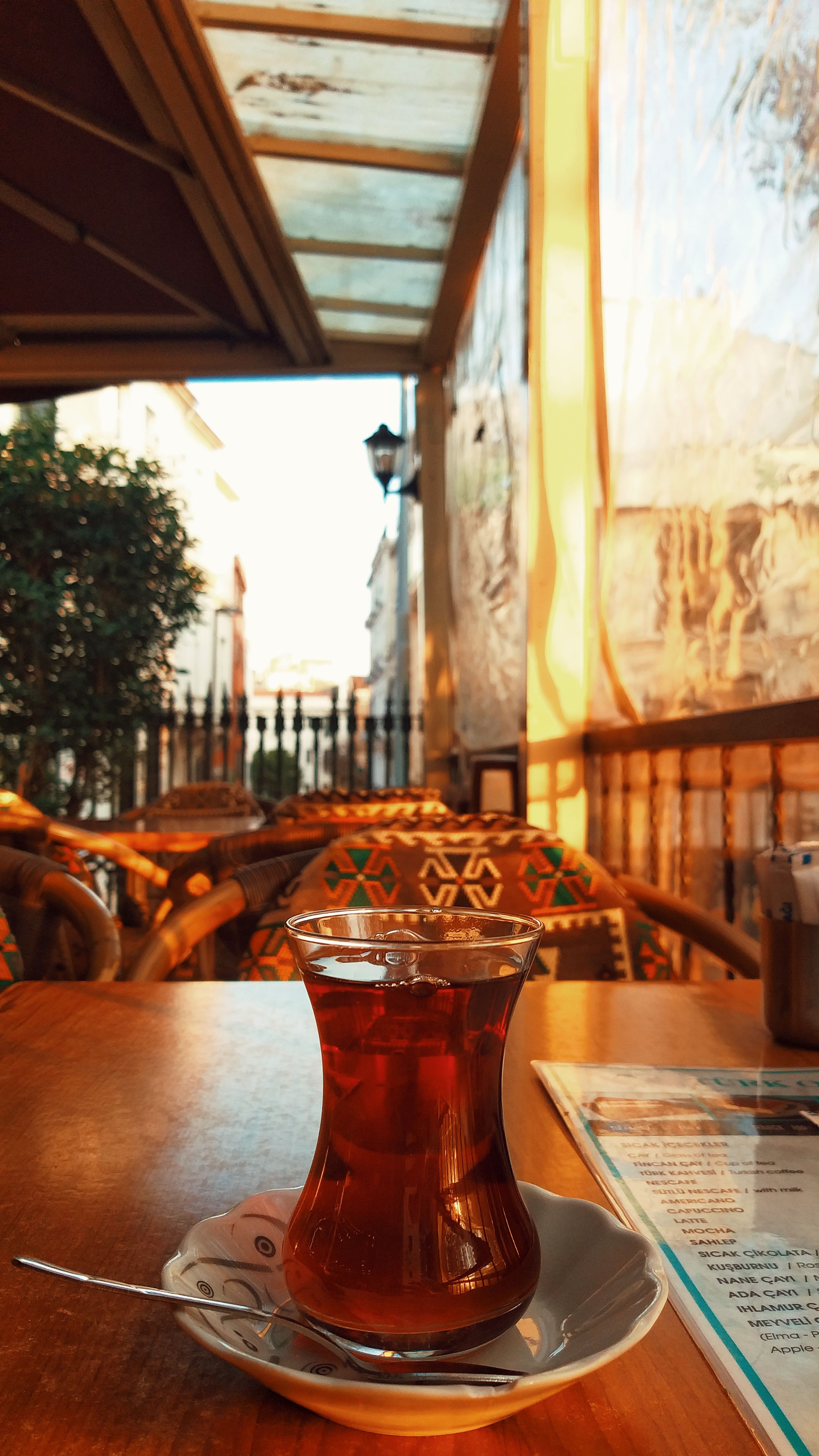 A warm outdoor café scene with Turkish tea under soft sunlight, perfect for a relaxed afternoon.