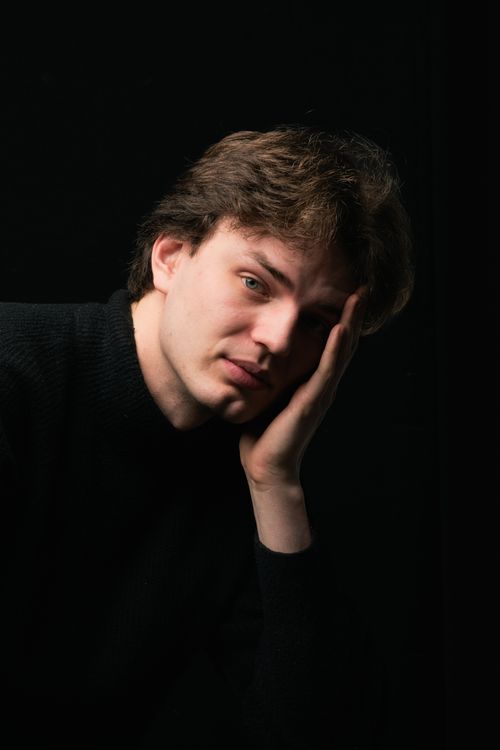 Free A contemplative man in a dark setting with dramatic lighting and deep shadows. Stock Photo