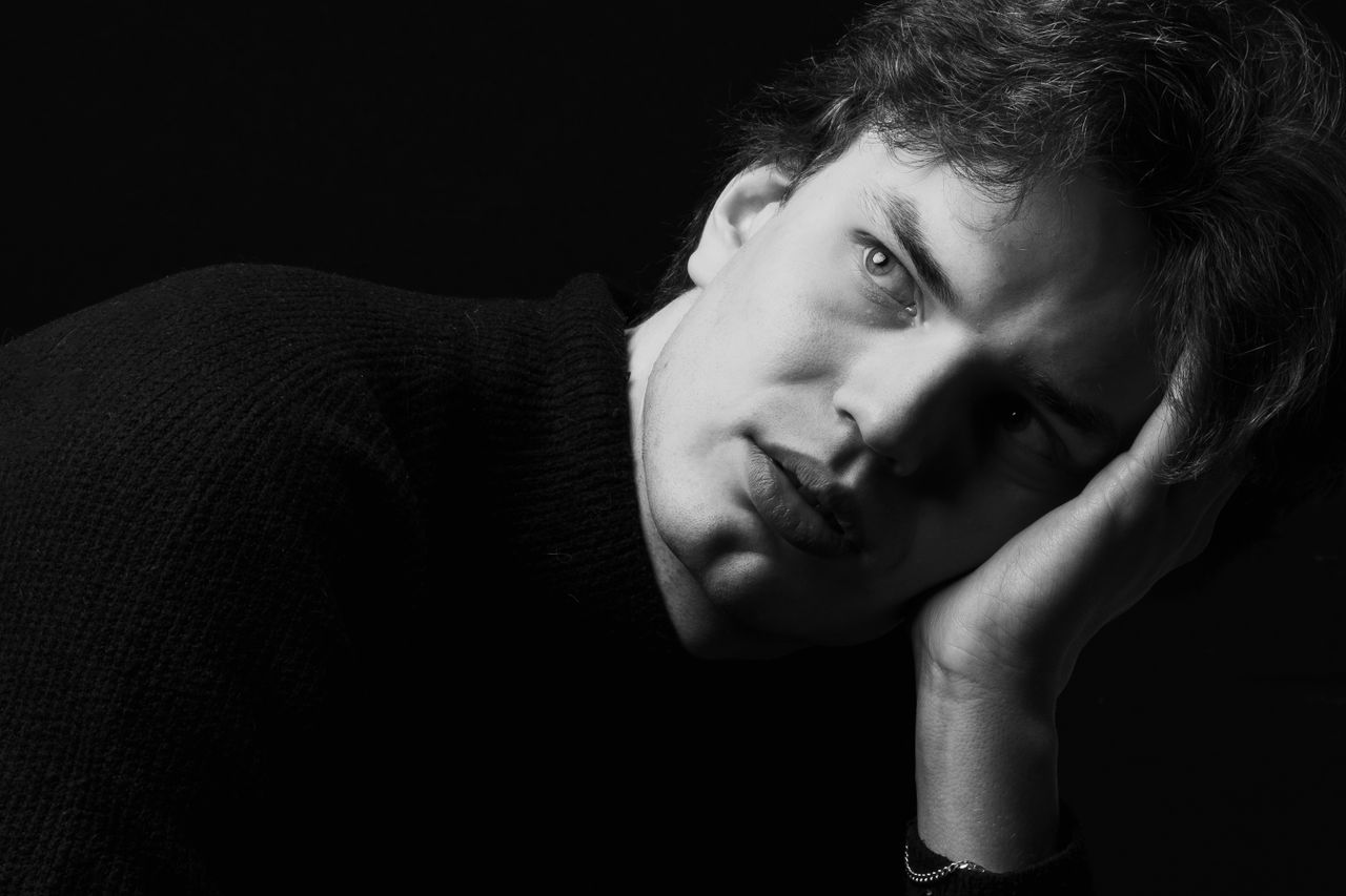a dramatic black and white portrait of a contemplative man with deep s