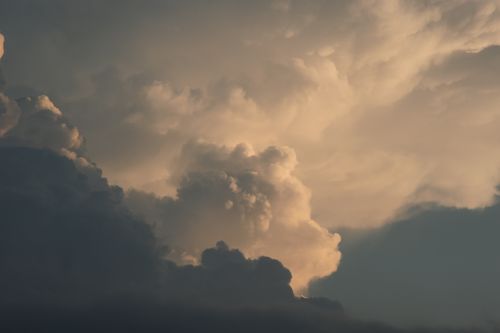 Free Stunning view of dramatic cumulonimbus clouds with golden sunlight highlighting their texture. Stock Photo