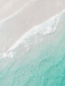 Breathtaking aerial view of a serene beach with white sand and turquoise waters, perfect for a tranquil summer escape.