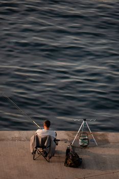 A lone fisherman enjoys a peaceful day fishing by the Bosphorus in Istanbul, Turkey.