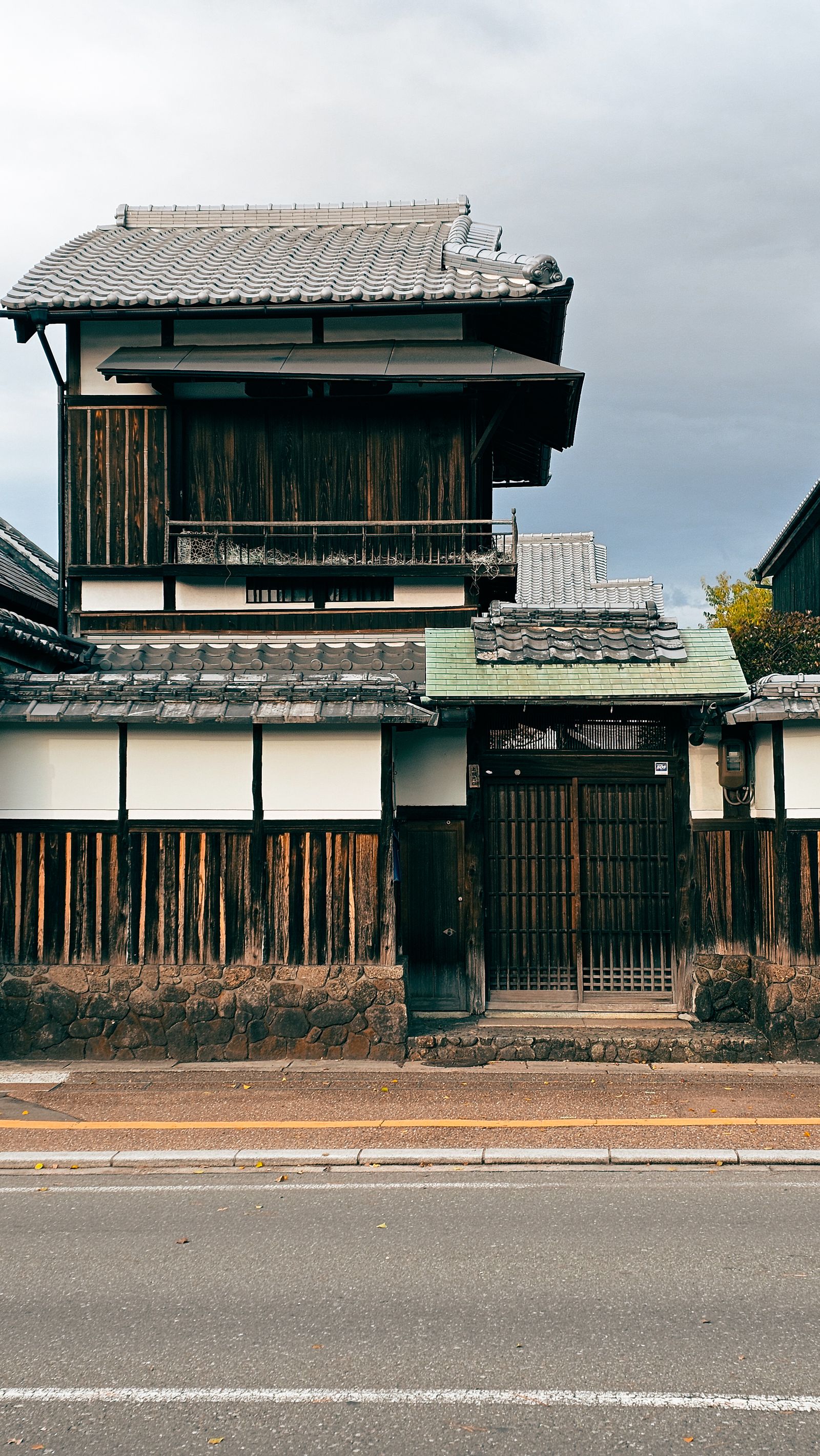 日本の木造瓦屋根の伝統建築、白壁と格子戸の正面