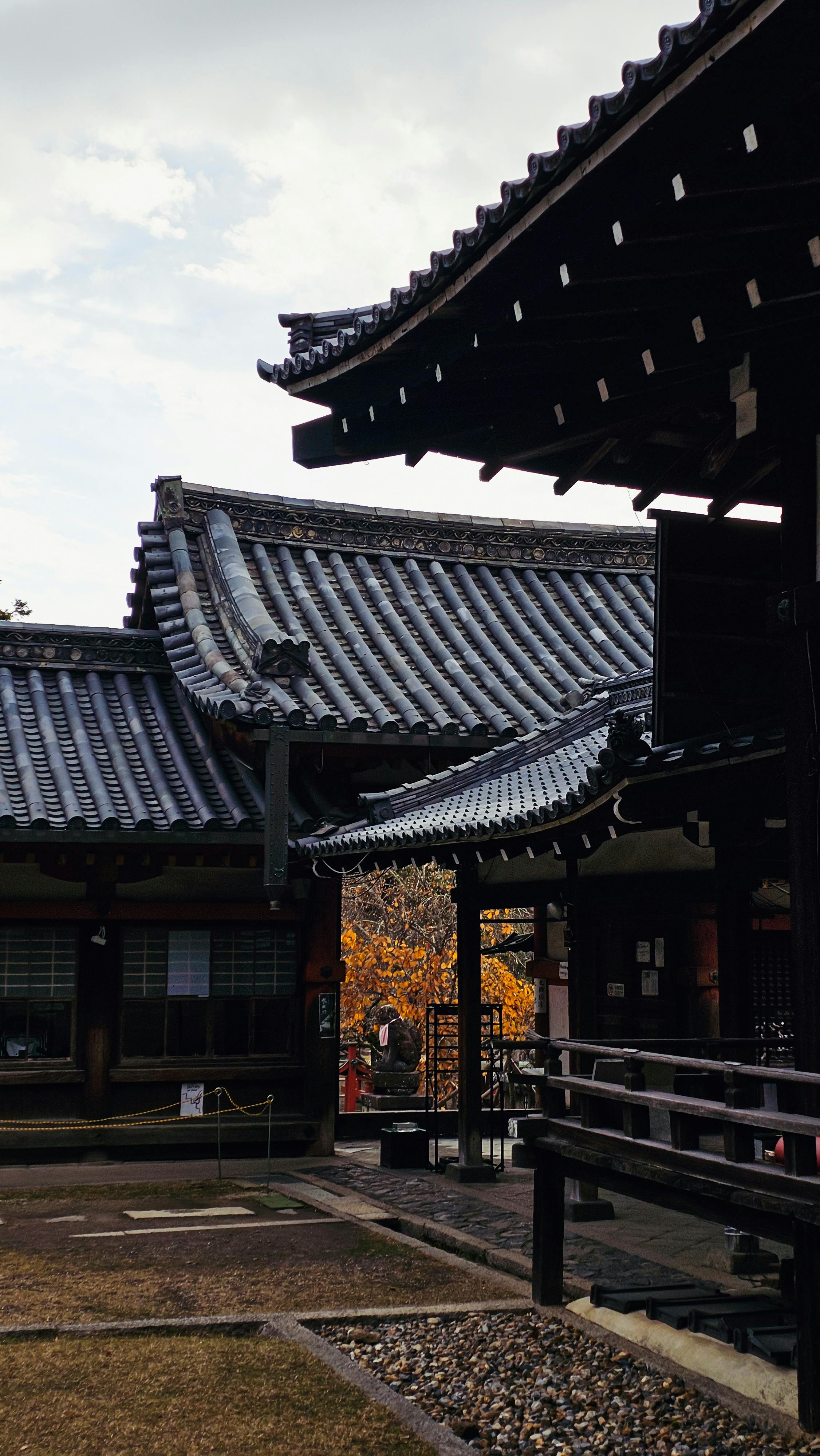 Explore the intricate details of a traditional Japanese temple with ornate roofs and serene surroundings.