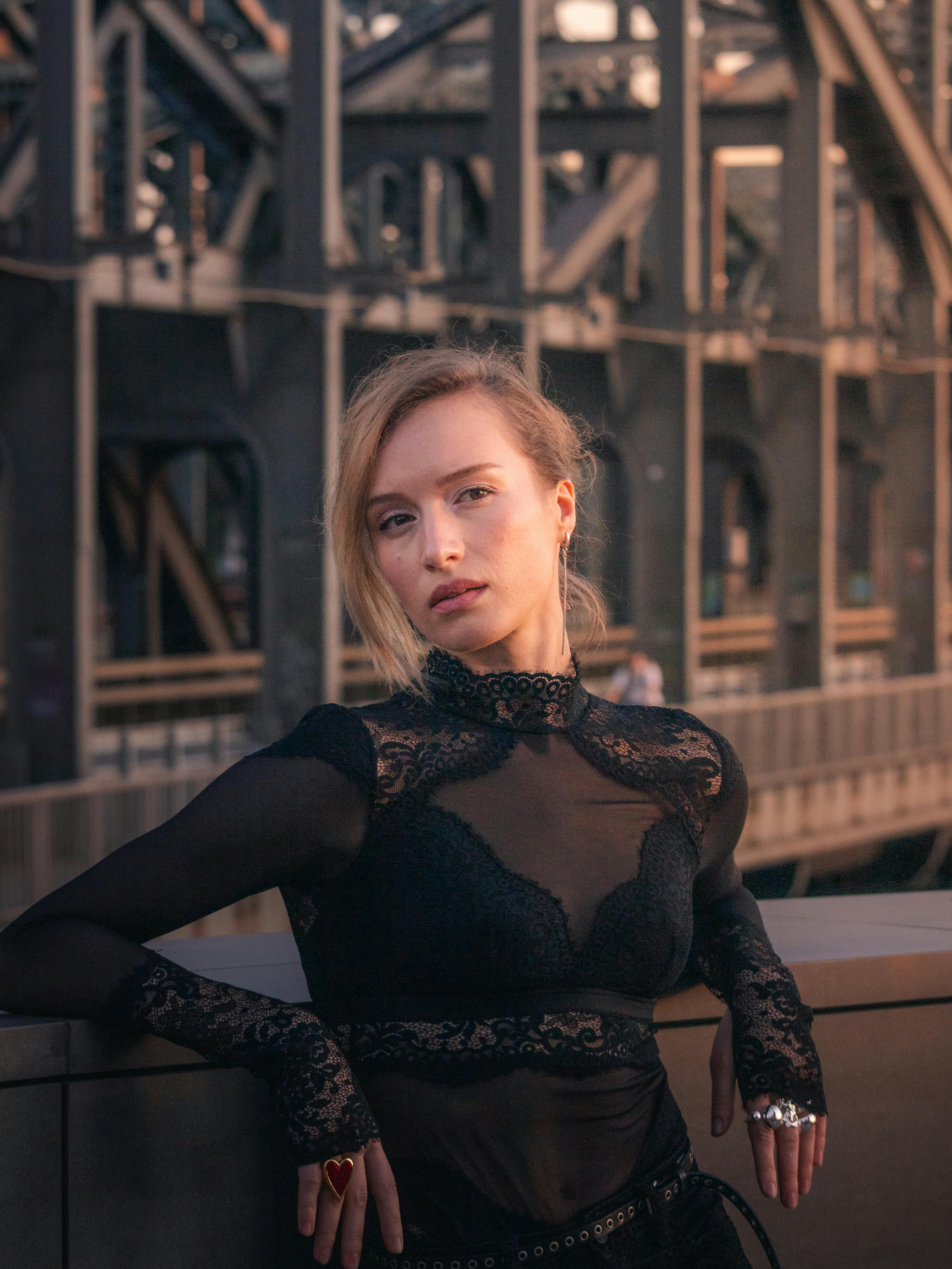 Elegant portrait of a woman in black lace attire at sunset in Hamburg.