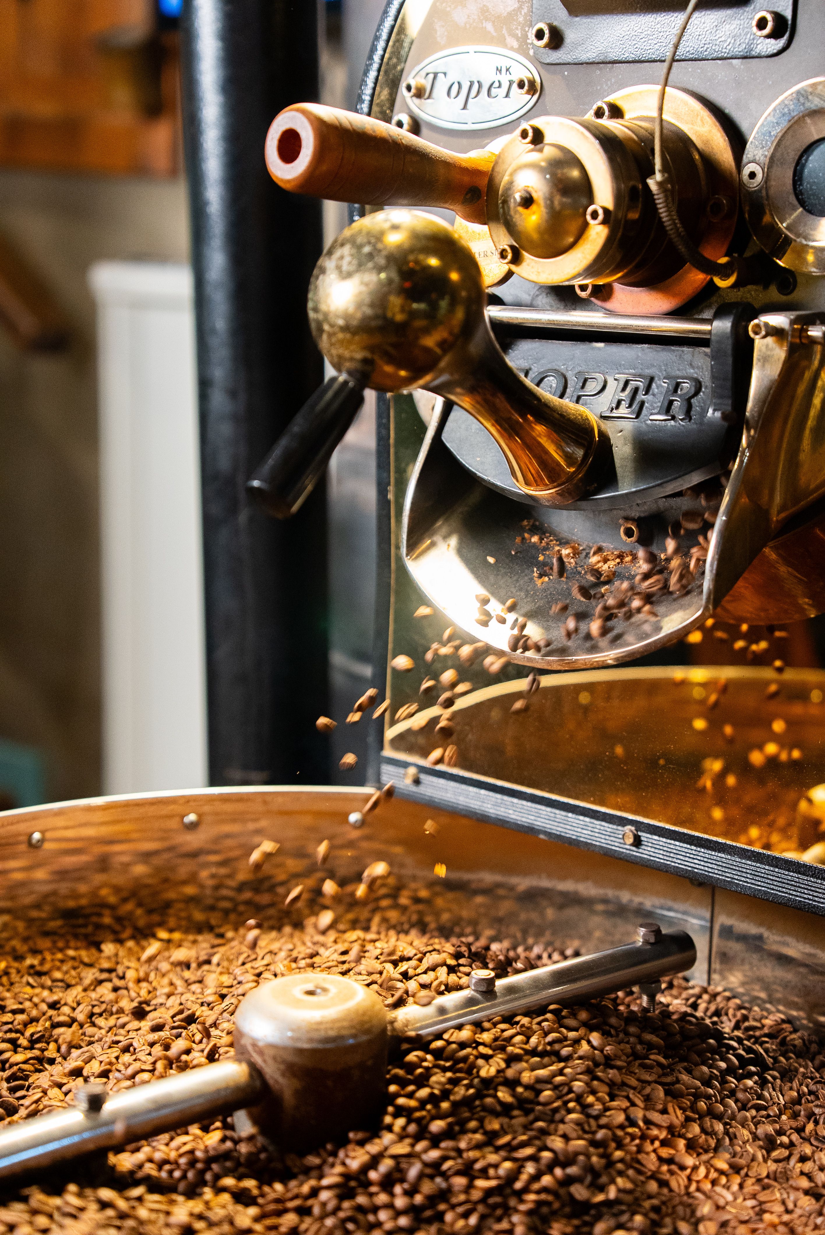 Close-up of coffee beans roasting in a professional coffee roaster machine.