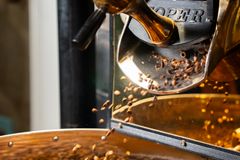Close-up of coffee beans roasting in a professional coffee roaster machine.