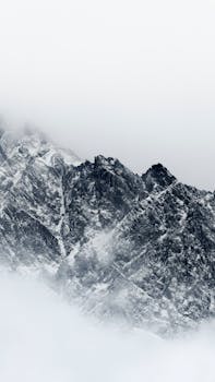 Breathtaking view of rocky, snow-covered peaks in the Greater Caucasus Mountains at Stepantsminda, Georgia.