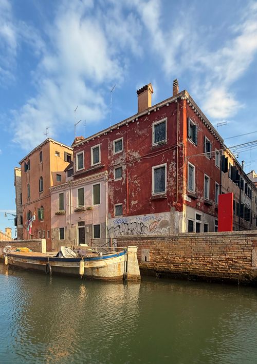 Free Picturesque Venice building by a tranquil canal, under a clear blue sky. Stock Photo