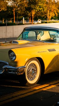 A vintage yellow Ford Thunderbird parked outdoors at sunset in San Bernardino, CA.