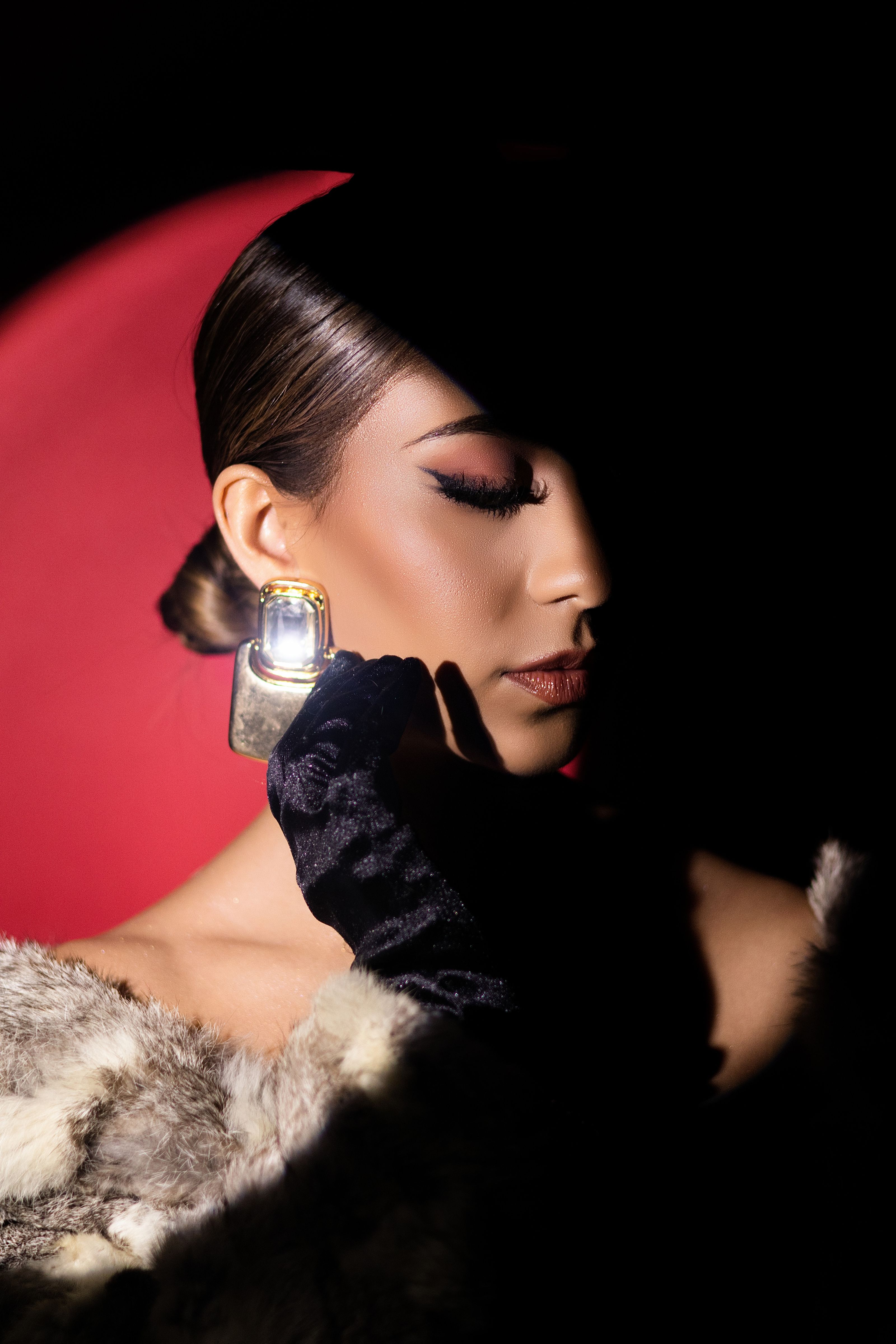 Retrato sofisticado de uma mulher em pele, apresentando um perfume de luxo com iluminação dramática.