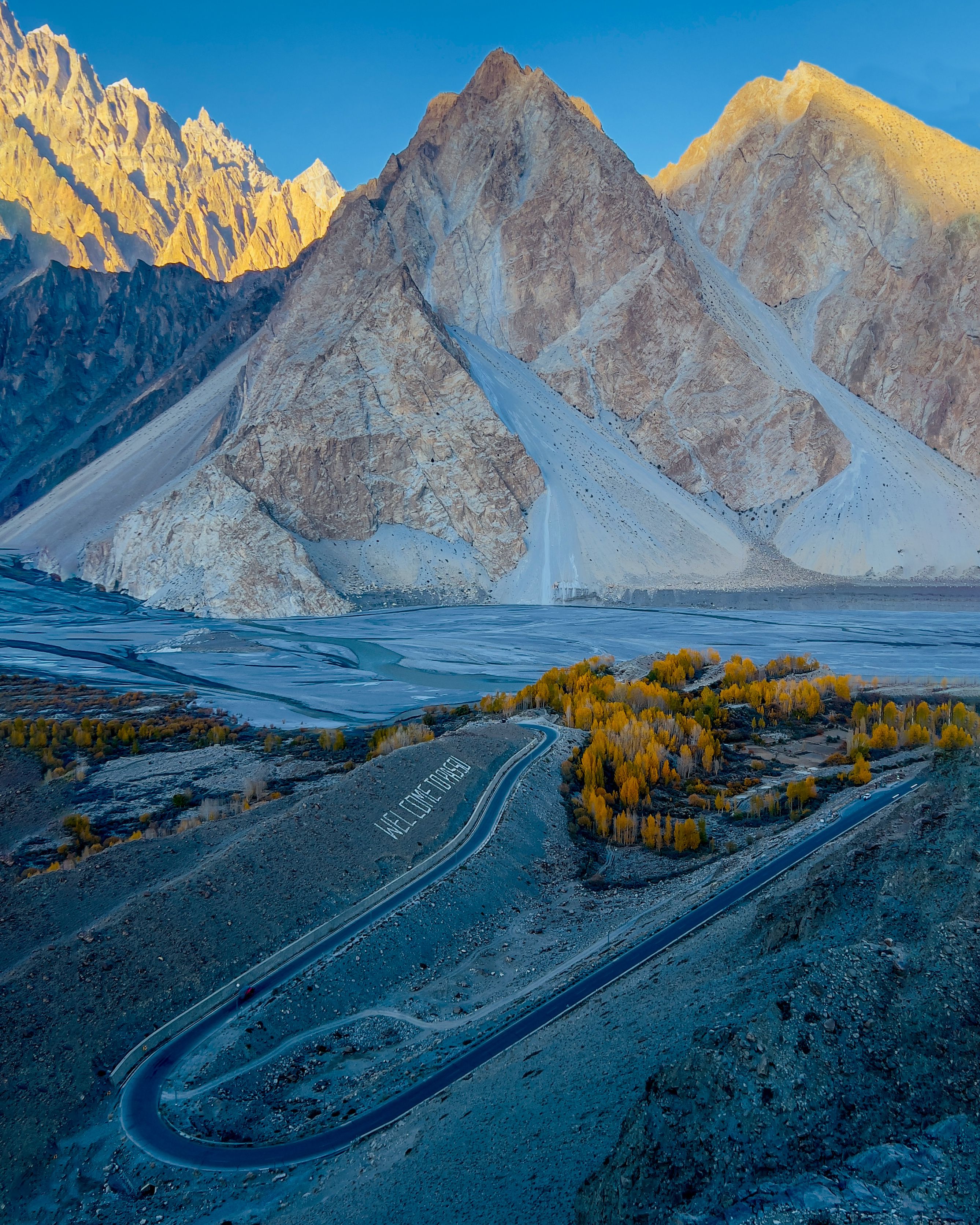 A breathtaking view of Passu Cones with winding roads and autumn colors in Pakistan.