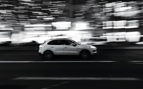 Free A sleek car speeds through illuminated streets in Berlin at night. Stock Photo