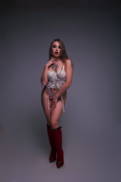 Free Artistic portrait of a woman in lingerie and red boots, exuding elegance. Stock Photo