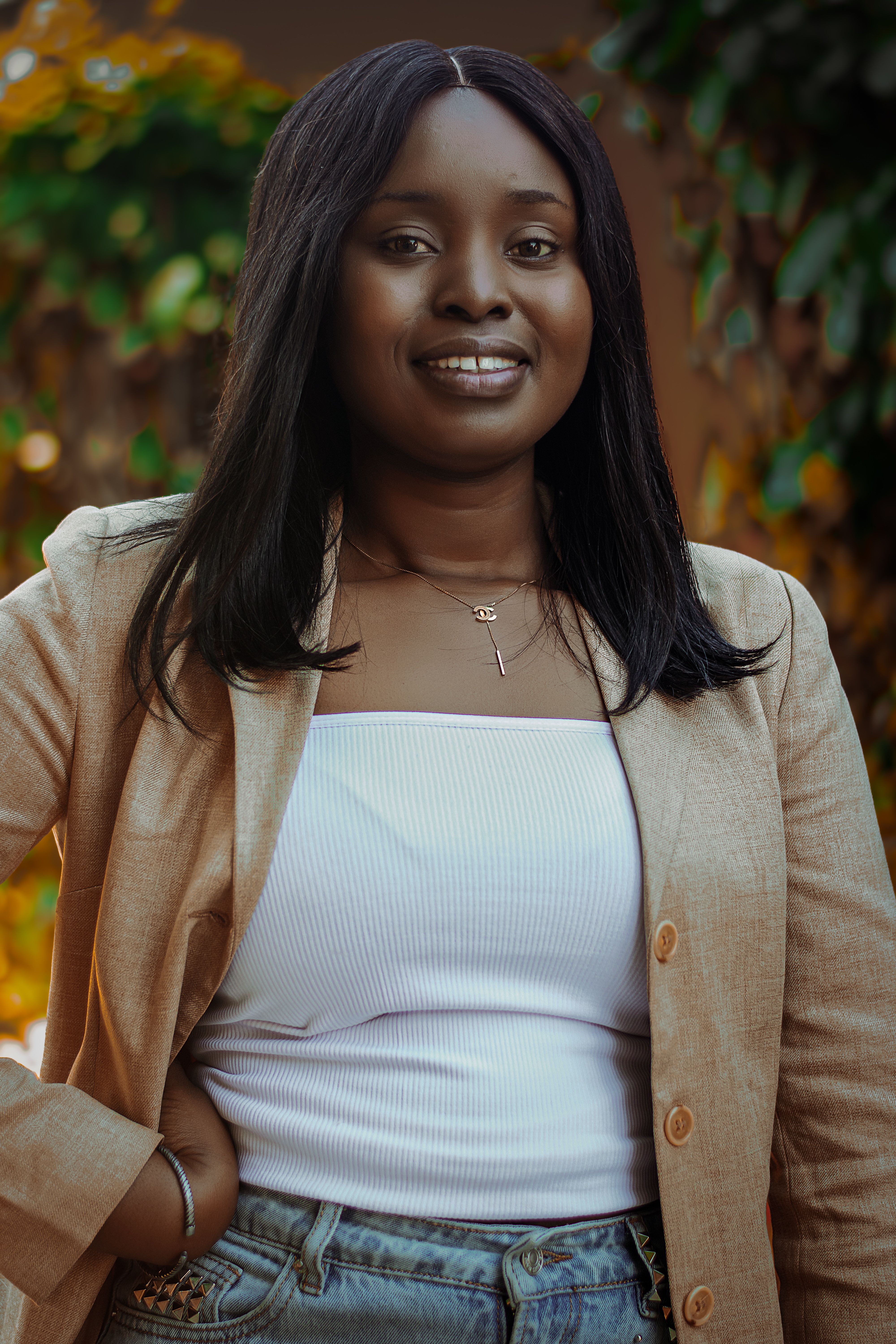 Confident African woman in a casual outfit posing outdoors with a warm smile in Dakar, Senegal.