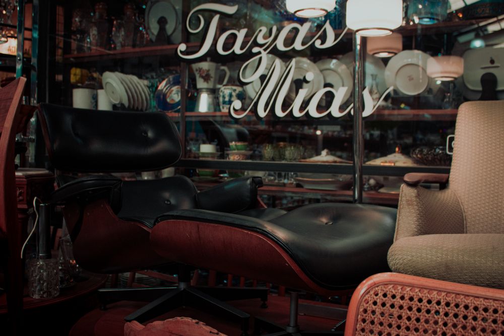 Vintage furniture and decor displayed in a chic storefront window, similar to the Cottage Rose shopfront in Edinboro