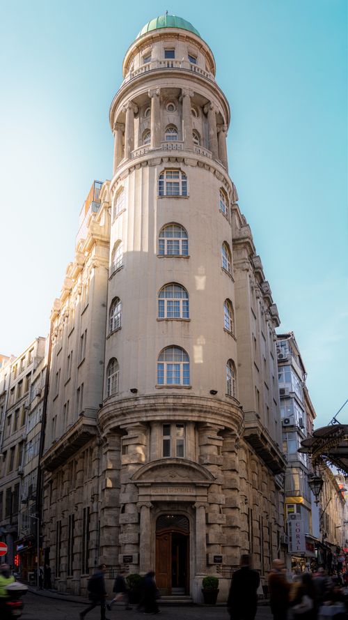 Free A classic cylindrical building with a green dome against a clear blue sky, showcasing early 20th-century architecture. Stock Photo