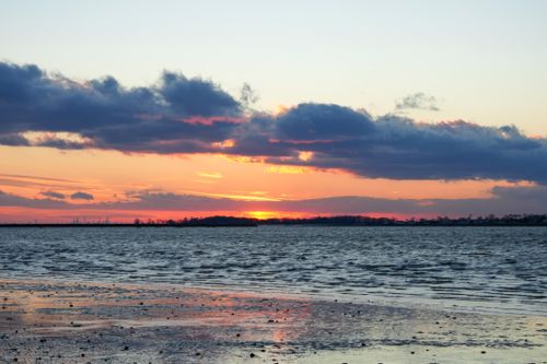 Free Beautiful beach sunset with vivid, colorful sky and dramatic clouds. Stock Photo