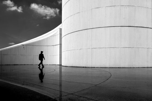 Free Silhouetted figure against modern architectural curves in black and white. Stock Photo