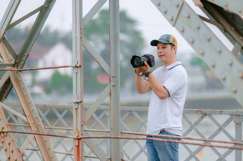 Free Man photographing scenic view from bridge with camera, outdoors. Stock Photo