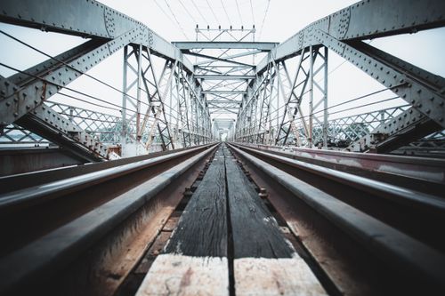 Free Low angle view of a symmetrical steel railway bridge illustrating industrial architecture. Stock Photo