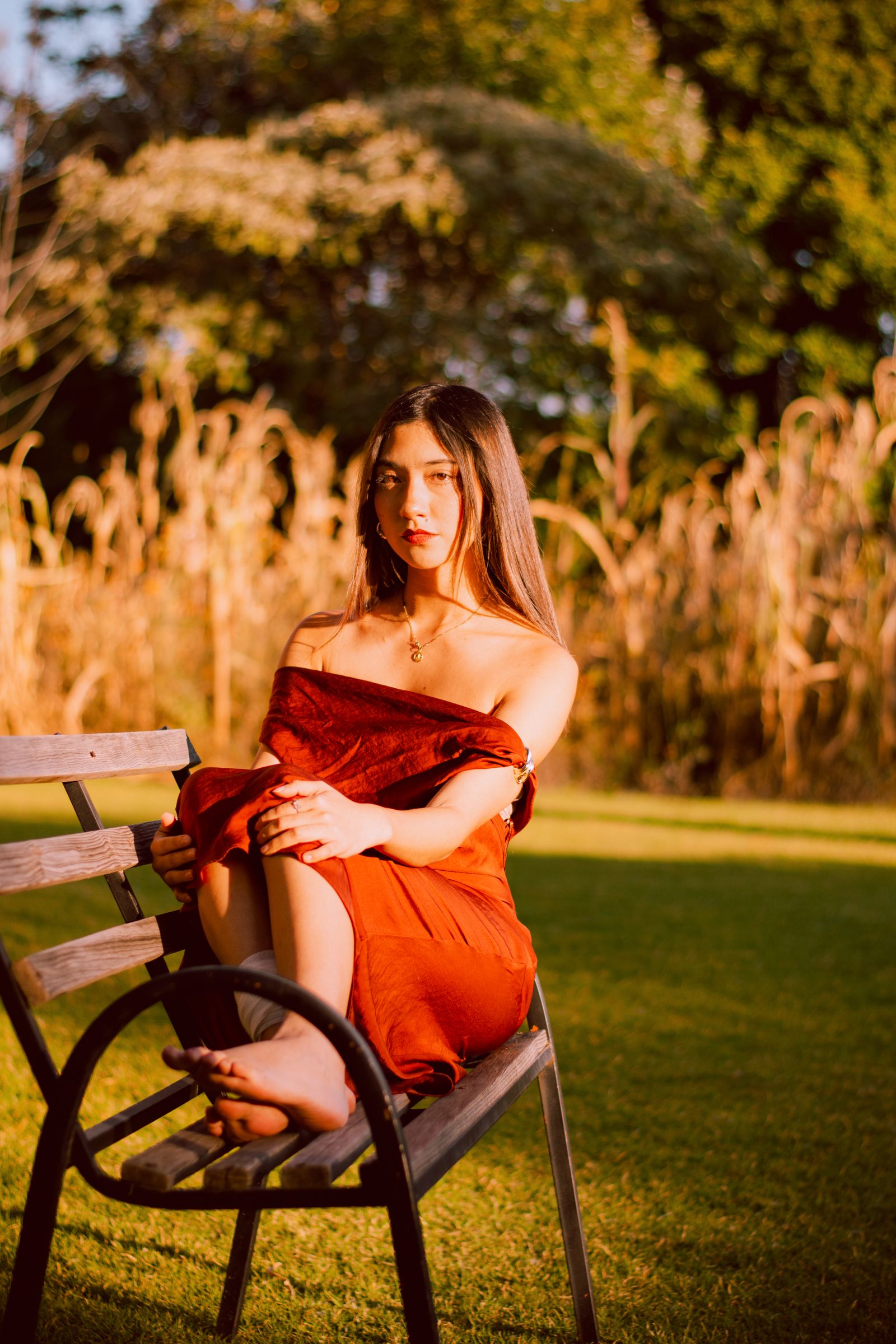 Woman in a Red Dress Sitting Alone on a Park Bench · Free Stock Photo