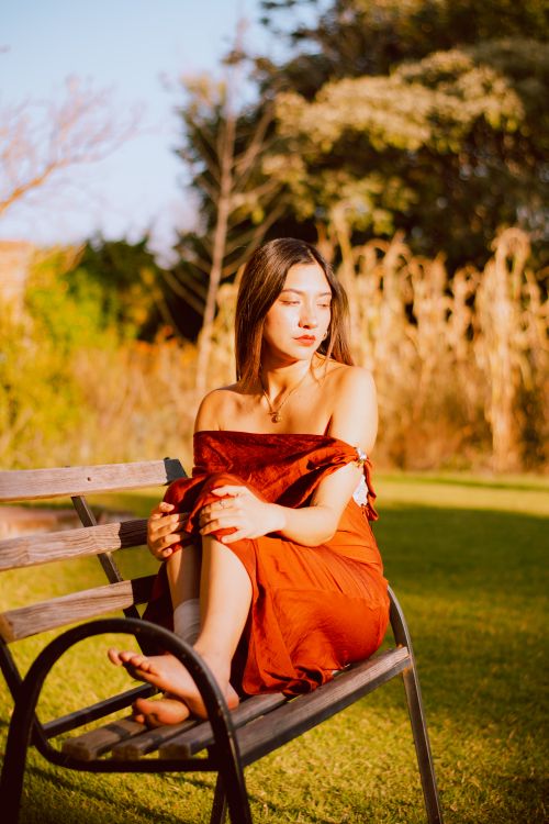 Young Woman in Red Dress Relaxing on Park Bench · Free Stock Photo