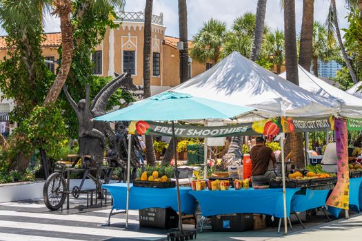 Fruit stalls under sunny skies in Miami Beach, featuring tropical produce and local art.