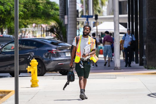 Un operaio edile cammina con sicurezza lungo le strade di Miami Beach in estate.