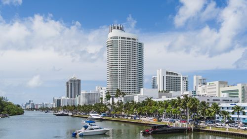Free Scenic view of Miami Beach skyline with luxurious waterfront and yachts under a blue sky. Stock Photo