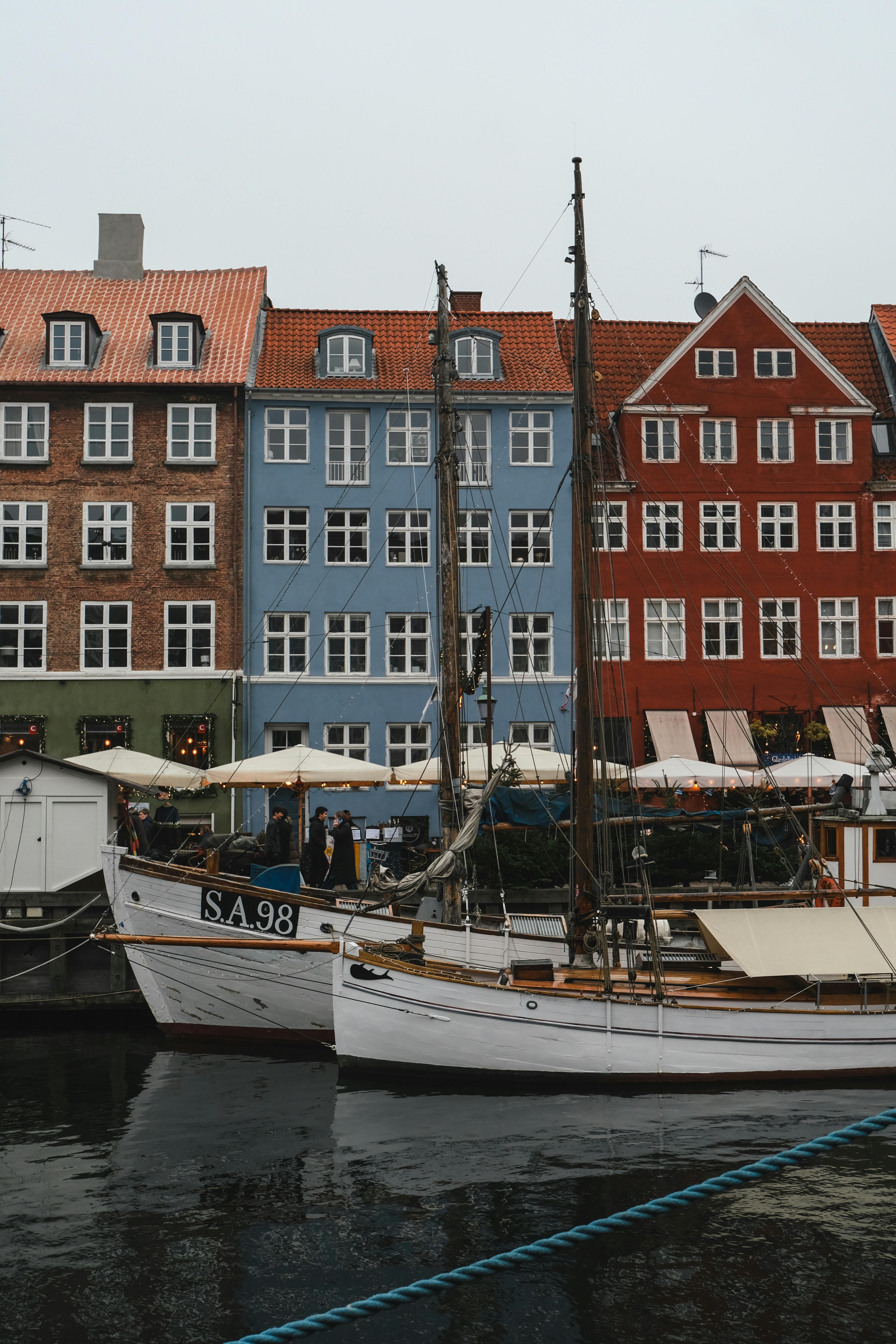 Colorful houses and boats along Nyhavn canal in Copenhagen during winter.