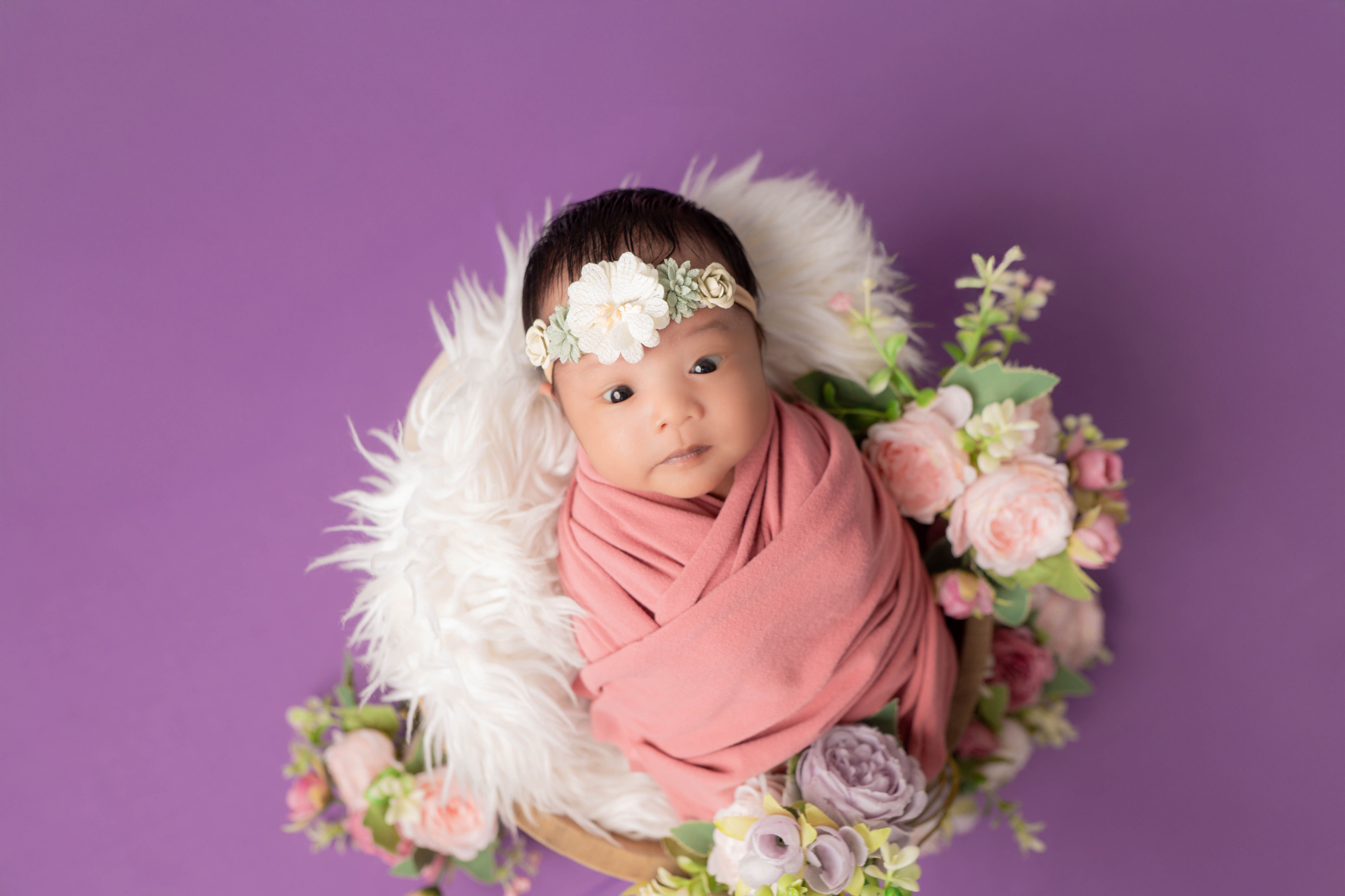 Adorable Baby in Pink Swaddle with Floral Decor · Free Stock Photo