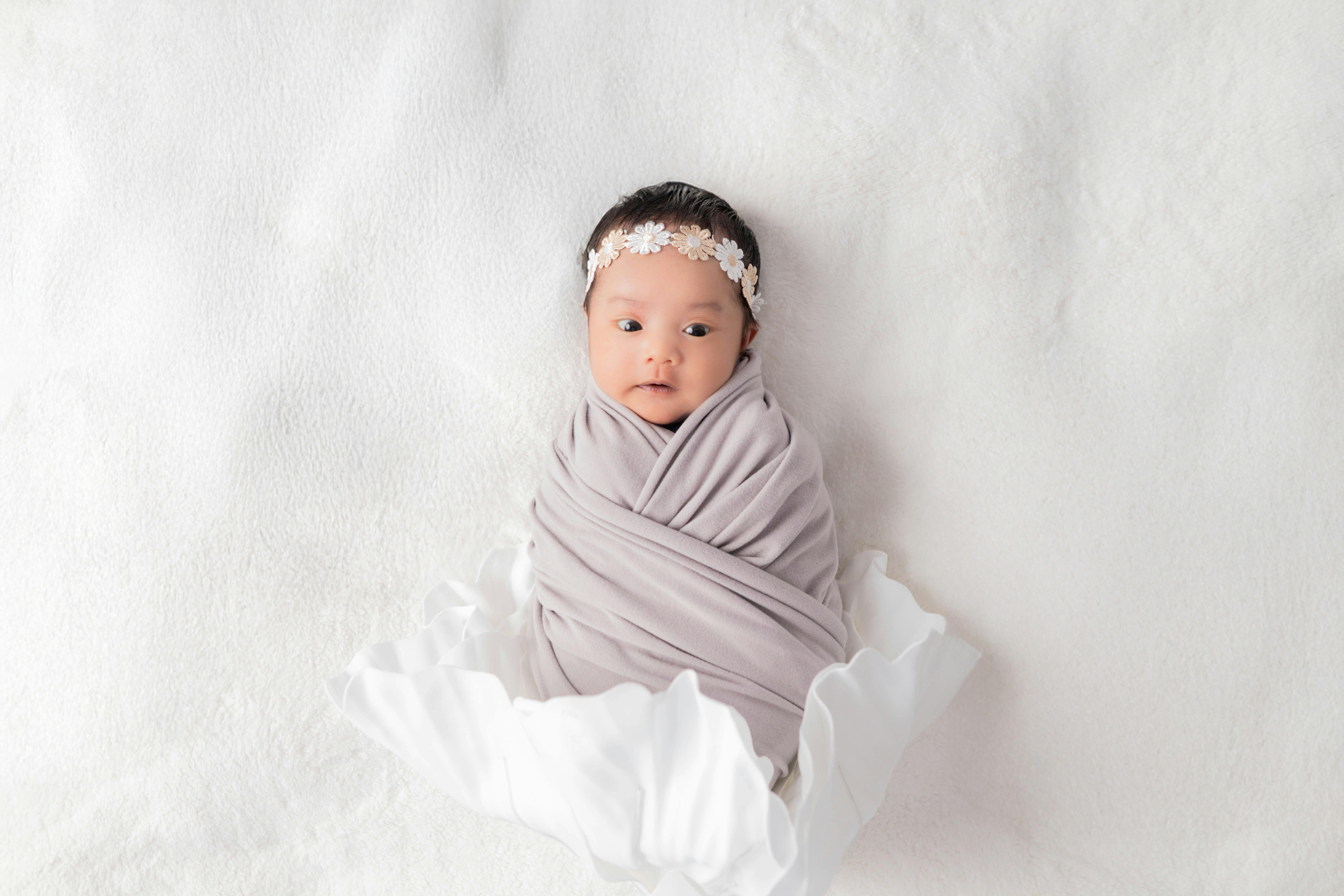 Different swaddle styles laid out on a soft surface