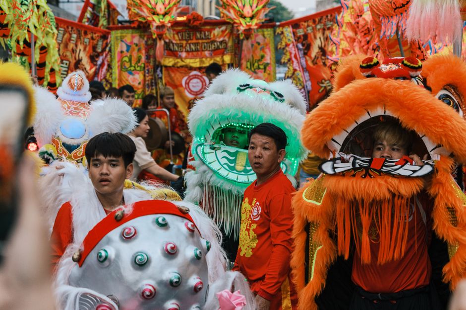 Colorful street parade with lion dance performers celebrating cultural festivities.