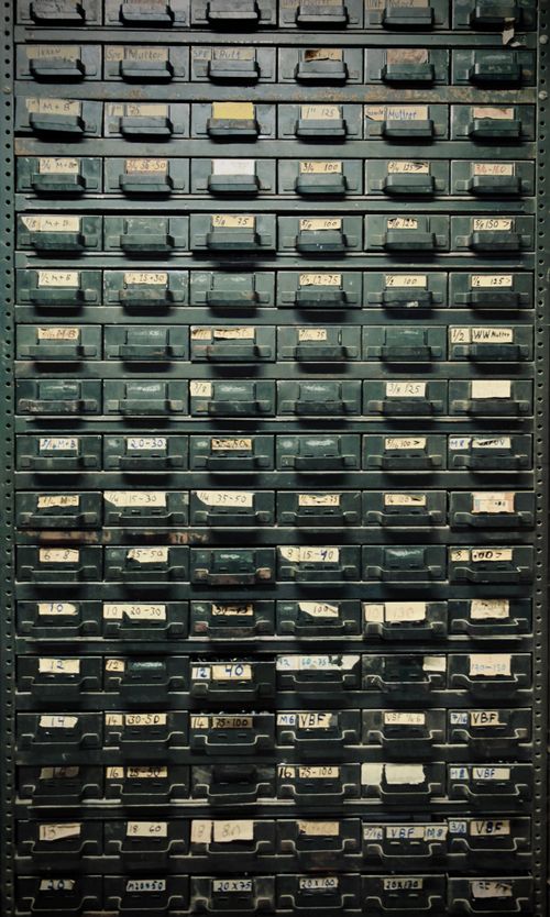Free A vintage metal cabinet with labeled drawers, ideal for industrial-themed decor. Stock Photo