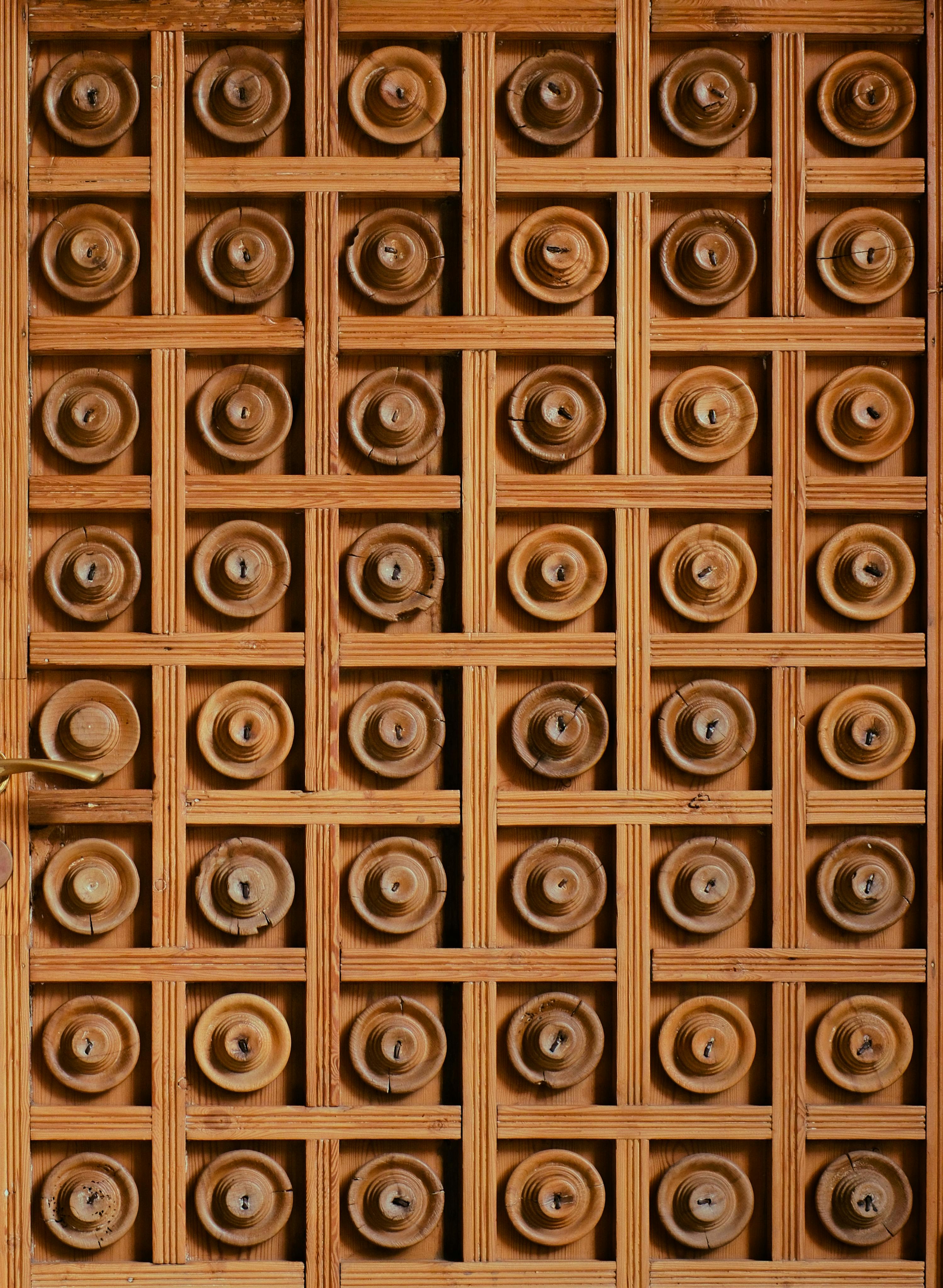 grátis Porta de madeira com entalhes intrincados, exibindo um padrão geométrico e o trabalho artesanal de um mestre em Barcelona. Foto profissional