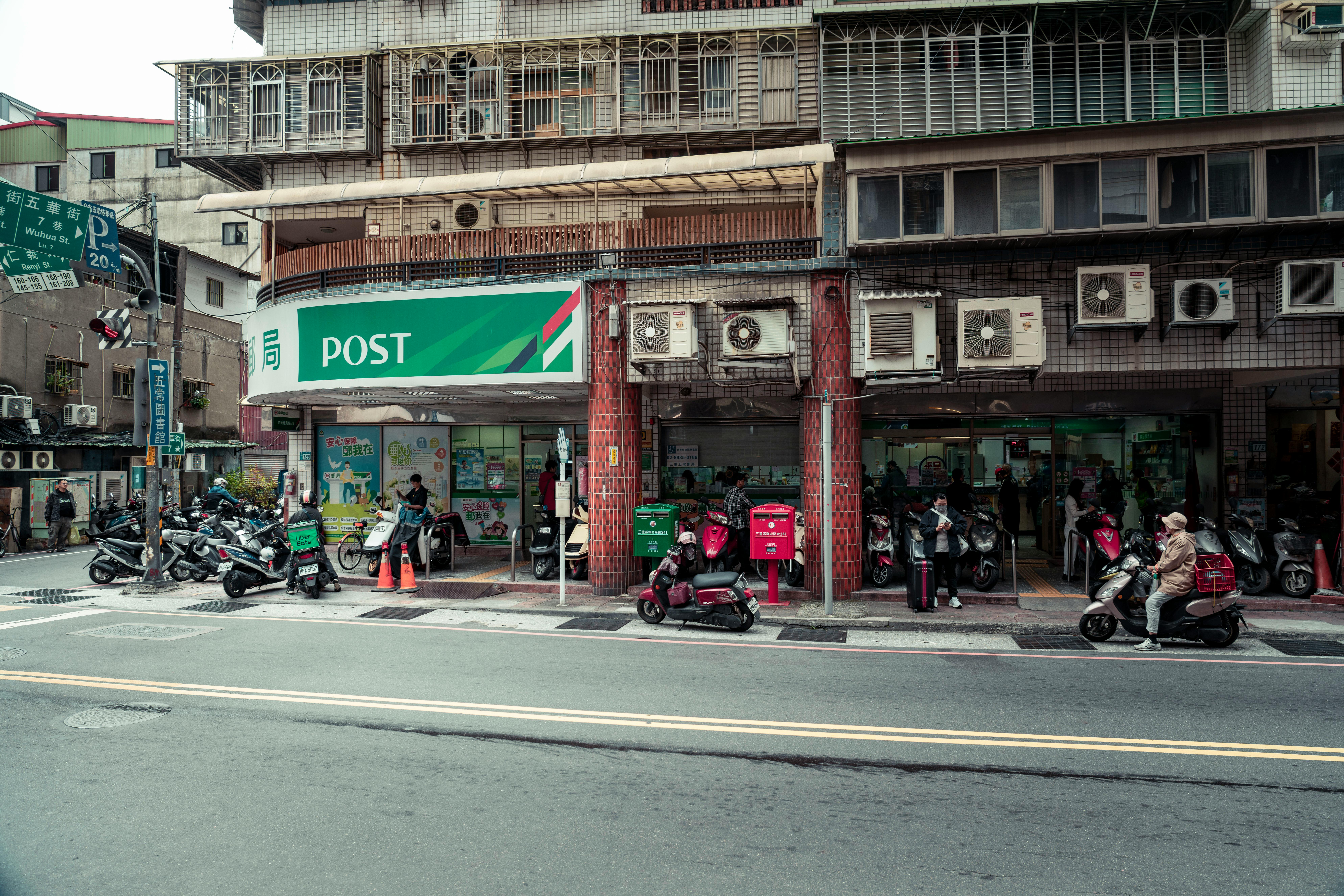 Vibrant street scene outside a post office in Taipei, Taiwan showcasing daily life.