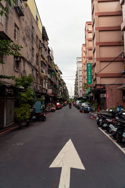 Free Busy urban street in New Taipei City with scooters and pedestrians, showcasing local architecture. Stock Photo