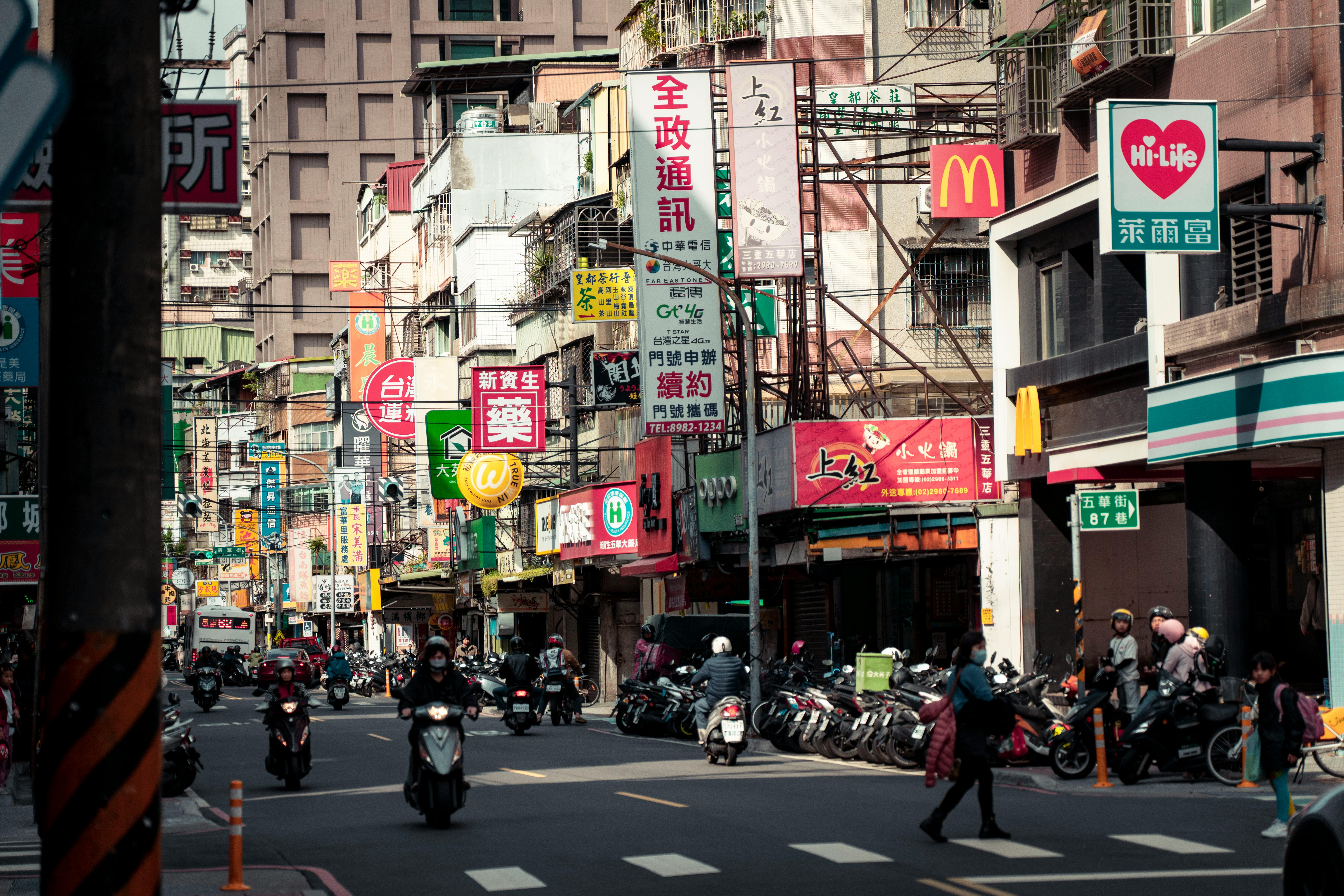 Busy urban street in New Taipei City showcasing local shops, signs, and traffic.