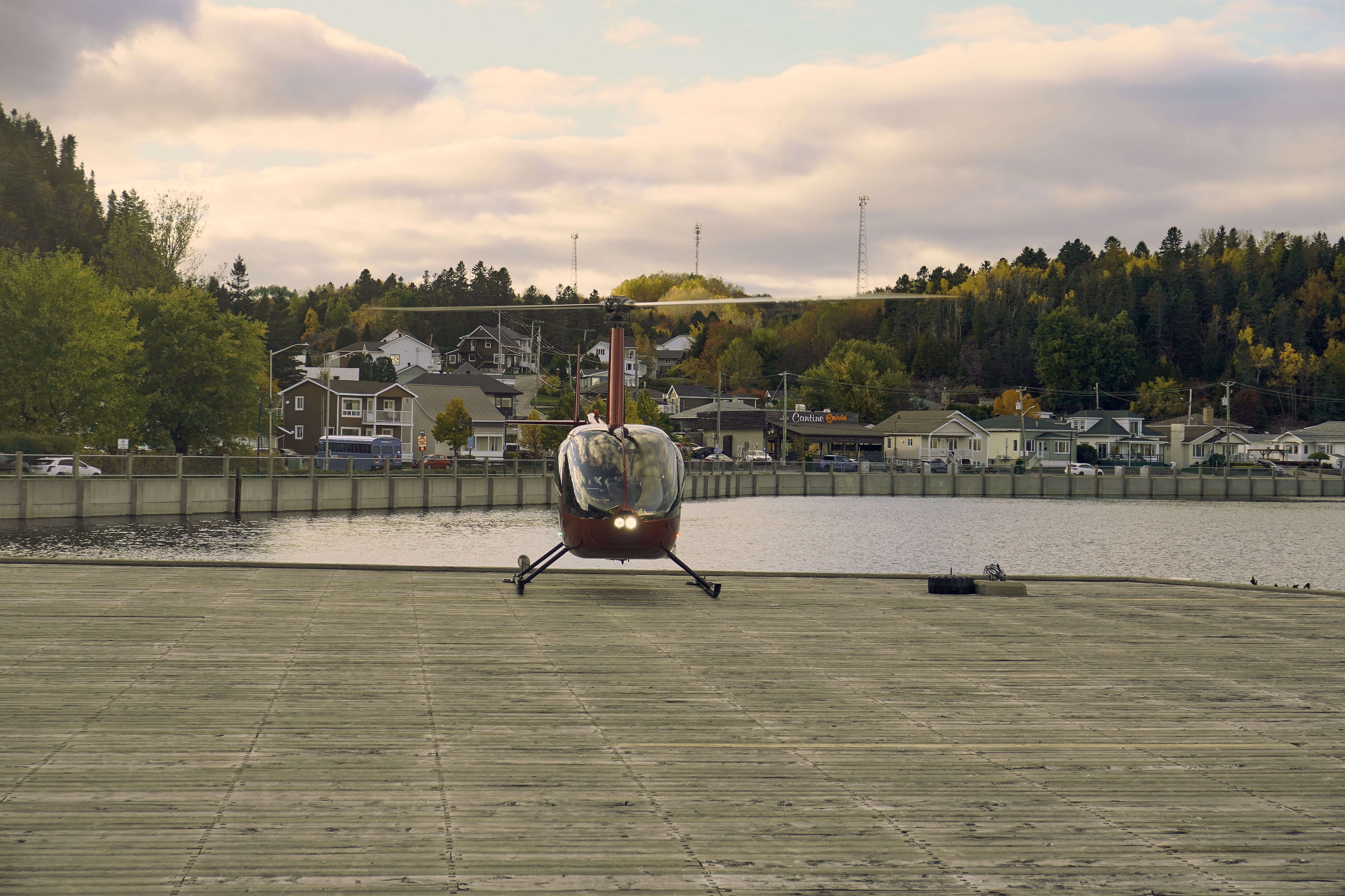 Helicopter Landing on Waterfront Platform in Autumn · Free Stock Photo