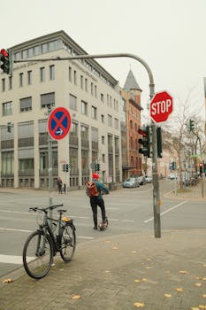 Busy city intersection in Mainz, Germany with e-scooter and bike parked nearby. Urban life and transportation theme.